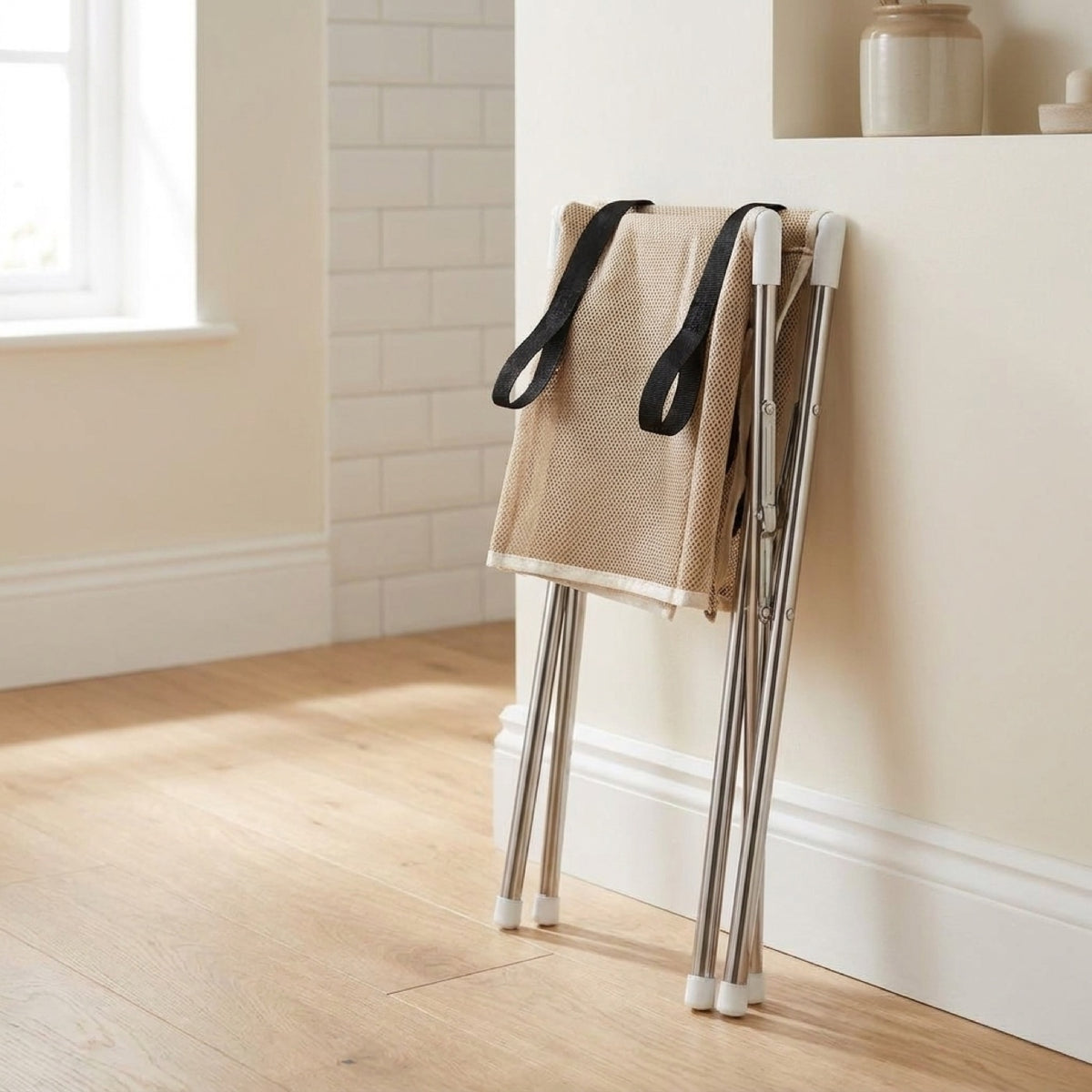 Pawperch grooming stand folded flat and stored upright against a bathroom wall